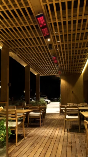 Heatscope Heaters Vision 3200W Radiant Heater wall‑mounted outdoors on a restaurant terrace, delivering electric infrared warmth.