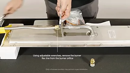 Using adjustable wrenches, remove the burner flex-line from the burner orifice